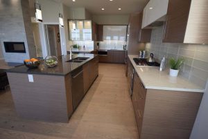 An array of rich finishes – two-tone quartz countertops, rift oak and off-white lacquer cabinets, taupe glass tile backsplash, warm, textured engineered oak hardwoods – plus a butler’s pantry equipped with an second sink – make the kitchen a functional, fashionable space.